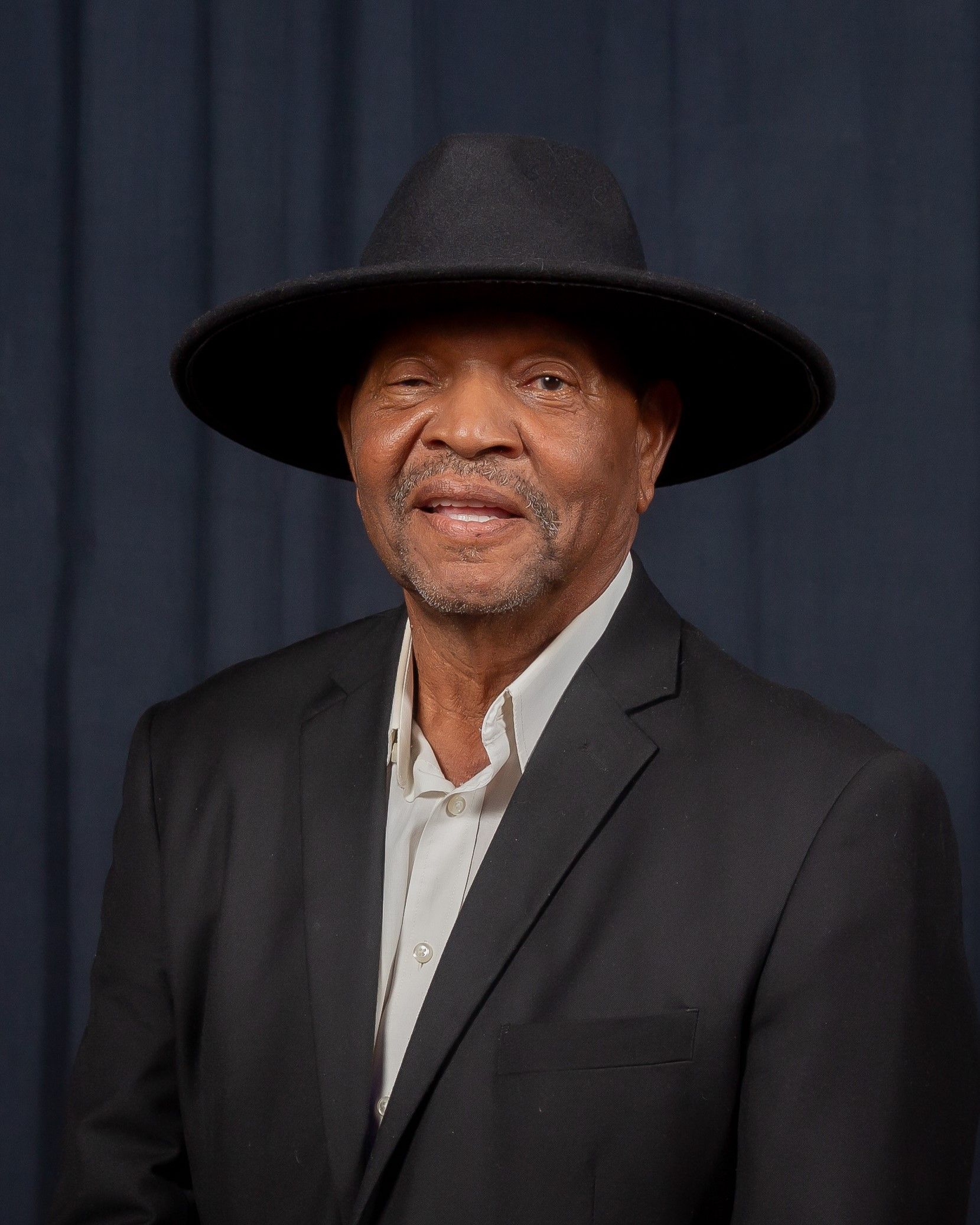 Dancing for the Arts star Amos McClorey, wearing a black blazer and brimmed hat